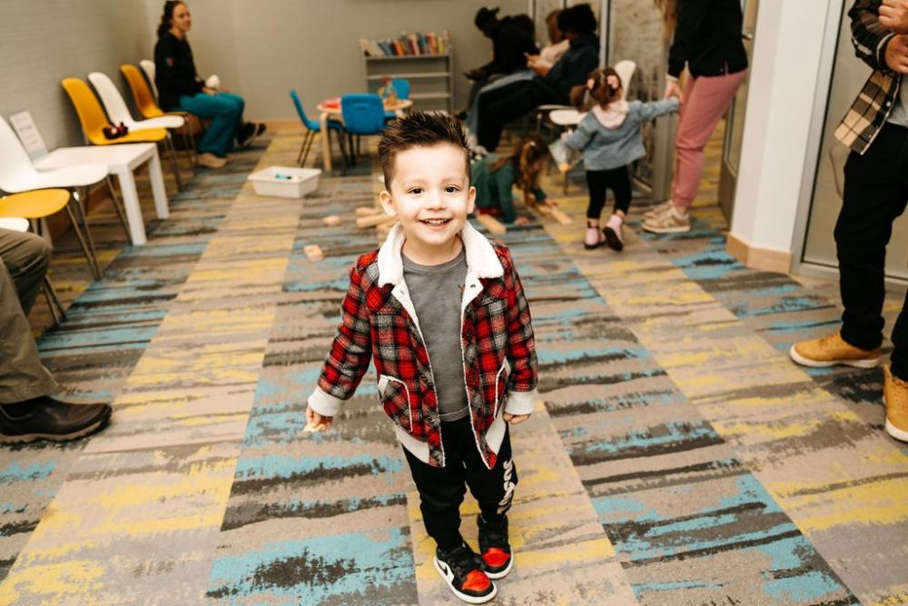 young boy in checkered jacket walking | pediatric dentist near me