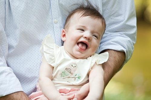 baby smiling in parent's arms l children's special health needs dentist apple valley mn