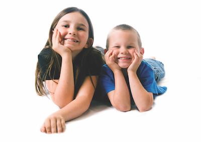 two children laying on floor smiling | pediatric dentist near me