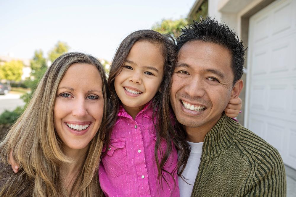 family of three hugging outside | minimally invasive dentistry apple valley