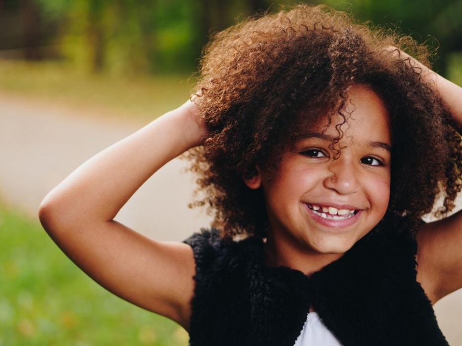 young girl with curly hair smiling | complimentary orthodontic apple valley