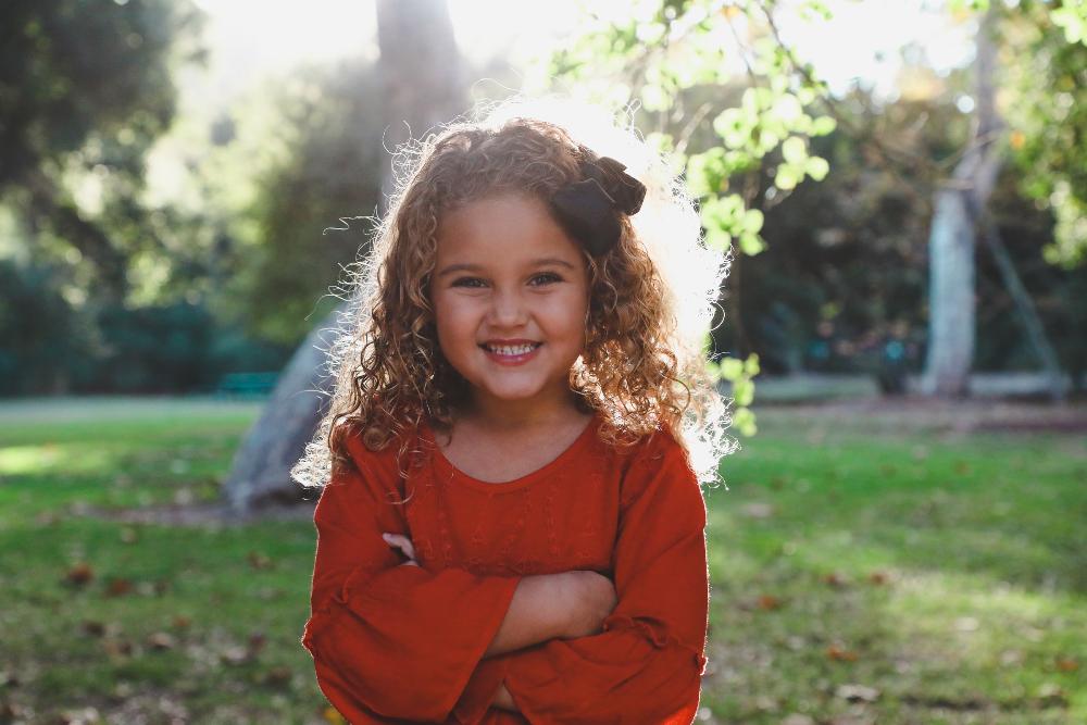 little girl with curly hair smiling | pediatric dentist near me