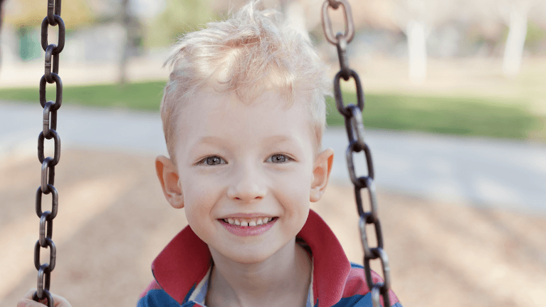 little boy in red shirt on swing | pediatric dentist apple valley mn