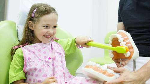 child using toothbrushing toy | preventive dental care apple valley mn