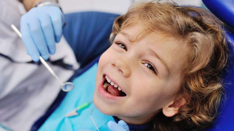 boy with curly hair smiling | pediatric dentist apple valley mn