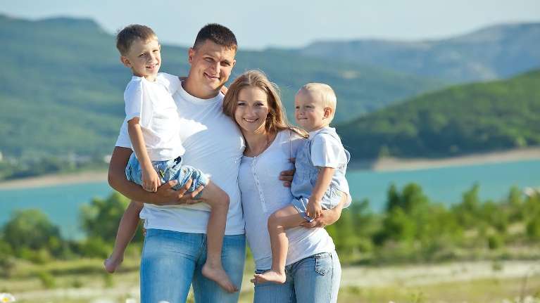 family wearing matching white shirts outside | hall crown dentist