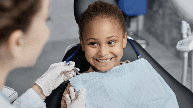 small child sitting in dentist exam chair | dental fillings apple valley mn