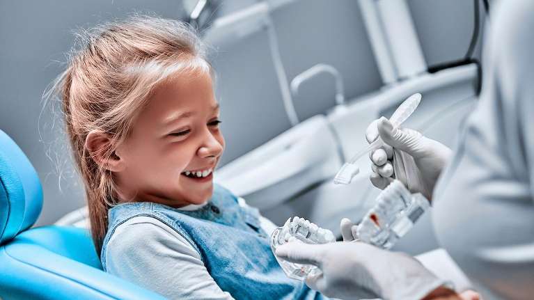 little girl laughing in dentist chair | pediatric dentist apple valley mn