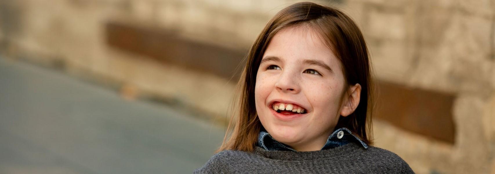 young girl with brown hair smiling l dentist for special needs child apple valley mn
